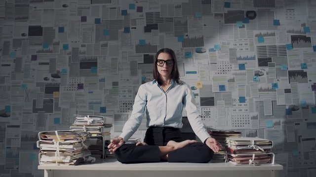 Collegues disturbing a businesswoman while she is meditating at work