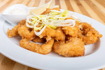 Grilled squid rings, with lemon and sauce.