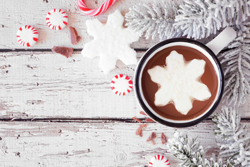 Hot chocolate with snowflake marshmallow. Top view corner border with snowy branches and candy...