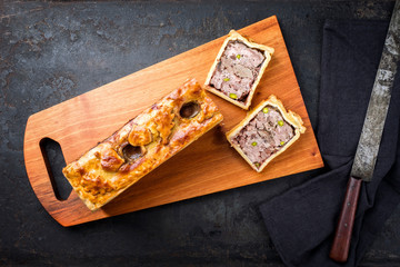 Traditional French Pate en croute with goose meat and liver as top view on a modern design wooden...