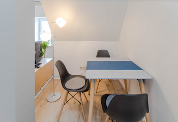 Modern light interior. Chairs and table in studio apartment.