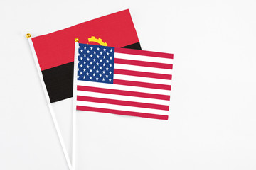 United States and Angola stick flags on white background. High quality fabric, miniature national flag. Peaceful global concept.White floor for copy space.