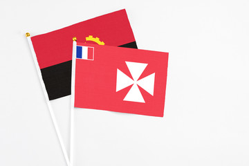 Wallis And Futuna and Angola stick flags on white background. High quality fabric, miniature...