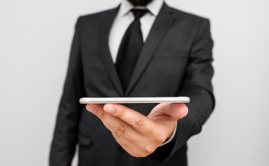 Male human wear formal work suit hold smart hi tech smartphone use one hand