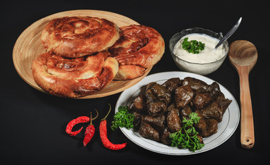 Dolma, sarmale, sarma, golubtsy or golabki with cheese pies and sour cream. Grape vines leaves stuffed with meat, rice and vegetables with sour cream. European traditional cuisine. Fresh sarmale