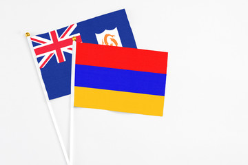 Armenia and Anguilla stick flags on white background. High quality fabric, miniature national flag. Peaceful global concept.White floor for copy space.