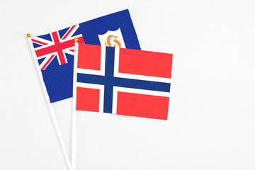 Fototapeta premium Bouvet Islands and Anguilla stick flags on white background. High quality fabric, miniature national flag. Peaceful global concept.White floor for copy space.