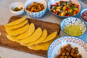 Vegan homemade delicious tacos with sweet potatoes, tofu, avocado sauce, jalapeno and mango salsa. Vegan and gluten free food.