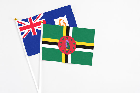 Dominica and Anguilla stick flags on white background. High quality fabric, miniature national flag. Peaceful global concept.White floor for copy space.