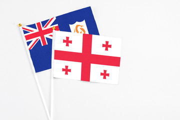 Georgia and Anguilla stick flags on white background. High quality fabric, miniature national flag. Peaceful global concept.White floor for copy space.