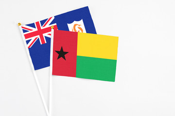 Guinea Bissau and Anguilla stick flags on white background. High quality fabric, miniature national flag. Peaceful global concept.White floor for copy space.