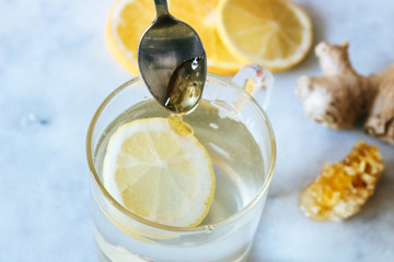 Glass of hot lemon and ginger tea with honey