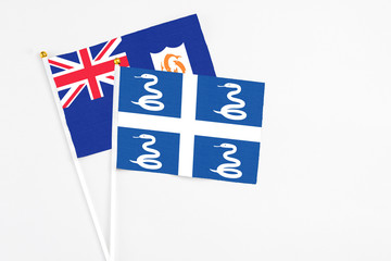 Martinique and Anguilla stick flags on white background. High quality fabric, miniature national flag. Peaceful global concept.White floor for copy space.