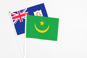 Mauritania and Anguilla stick flags on white background. High quality fabric, miniature national flag. Peaceful global concept.White floor for copy space.