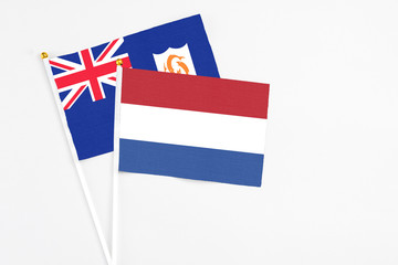Netherlands and Anguilla stick flags on white background. High quality fabric, miniature national flag. Peaceful global concept.White floor for copy space.