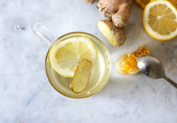 Glass of hot lemon and ginger tea with honey