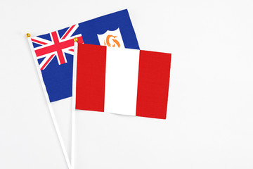 Peru and Anguilla stick flags on white background. High quality fabric, miniature national flag. Peaceful global concept.White floor for copy space.