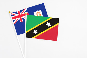 Saint Kitts And Nevis and Anguilla stick flags on white background. High quality fabric, miniature national flag. Peaceful global concept.White floor for copy space.