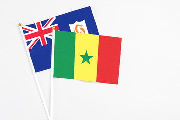 Senegal and Anguilla stick flags on white background. High quality fabric, miniature national flag. Peaceful global concept.White floor for copy space.