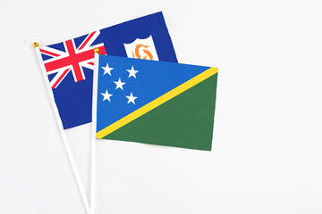 Solomon Islands and Anguilla stick flags on white background. High quality fabric, miniature national flag. Peaceful global concept.White floor for copy space.