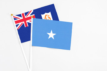 Fototapeta premium Somalia and Anguilla stick flags on white background. High quality fabric, miniature national flag. Peaceful global concept.White floor for copy space.