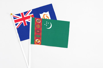 Turkmenistan and Anguilla stick flags on white background. High quality fabric, miniature national flag. Peaceful global concept.White floor for copy space.