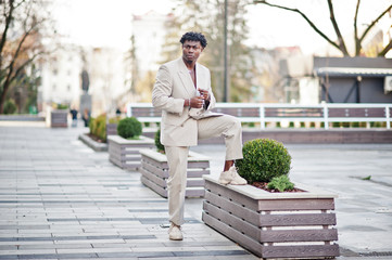 Stylish afro man in beige old school suit. Fashionable young African male in casual jacket on bare torso.