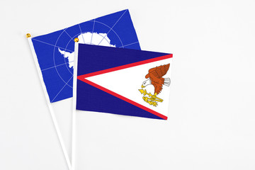American Samoa and Antarctica stick flags on white background. High quality fabric, miniature national flag. Peaceful global concept.White floor for copy space.