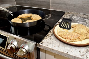 Pan frying breaded chicken fillets for family dinner