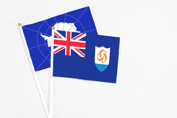 Anguilla and Antarctica stick flags on white background. High quality fabric, miniature national flag. Peaceful global concept.White floor for copy space.