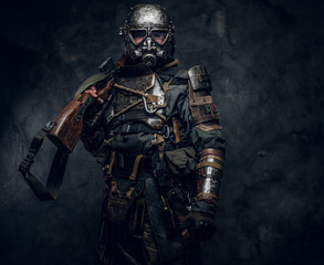 Fototapeta na wymiar Portrait of a man in interesting costume of dark apocalypse warrior at photo studio.