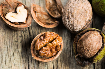 Ripe and raw whole big walnut kernel with thin shell on wooden rustic backdrop. healthy nut food for brain. Fresh walnuts background concept