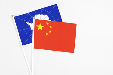 China and Antarctica stick flags on white background. High quality fabric, miniature national flag. Peaceful global concept.White floor for copy space.
