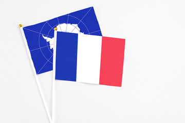 France and Antarctica stick flags on white background. High quality fabric, miniature national flag. Peaceful global concept.White floor for copy space.