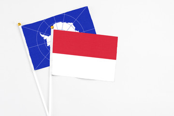 Indonesia and Antarctica stick flags on white background. High quality fabric, miniature national flag. Peaceful global concept.White floor for copy space.