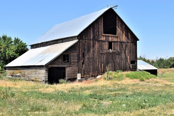 Obraz premium Old Wooden Barn Stand Test of Time on Farmland in Washington State