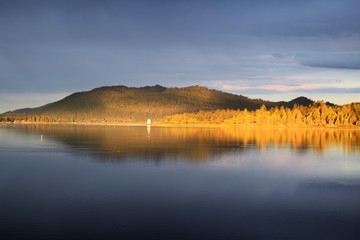 Sunrise Turns Pine Trees Orange Surrounding Calm Mirrored Lake
