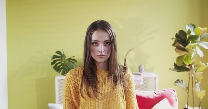 Provocative mad young woman standing showing middle finger hand gesture at camera posing in middle of studio or living room.