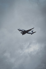 Fototapeta na wymiar Aeroplane in the cloudy sky is flying from aeroport after summer rain.