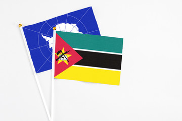 Mozambique and Antarctica stick flags on white background. High quality fabric, miniature national flag. Peaceful global concept.White floor for copy space.
