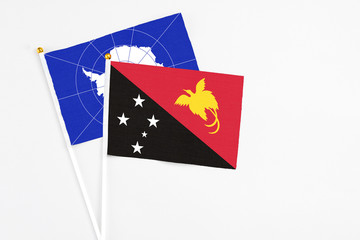 Papua New Guinea and Antarctica stick flags on white background. High quality fabric, miniature national flag. Peaceful global concept.White floor for copy space.