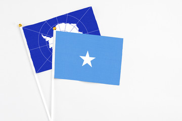 Somalia and Antarctica stick flags on white background. High quality fabric, miniature national flag. Peaceful global concept.White floor for copy space.