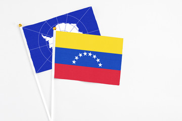 Venezuela and Antarctica stick flags on white background. High quality fabric, miniature national flag. Peaceful global concept.White floor for copy space.