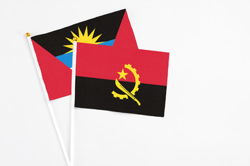 Angola and Antigua and Barbuda stick flags on white background. High quality fabric, miniature...