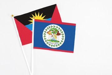 Belize and Antigua and Barbuda stick flags on white background. High quality fabric, miniature national flag. Peaceful global concept.White floor for copy space.