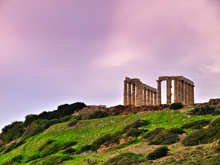Sunset at Ancient ruins of Poseidon temple under sky with clouds in winter time  in Sounio, Attica, Greece.