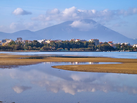 Mountain and sky reflection on sea water during low tide, Liani Ammos in Chalkida, Greece.