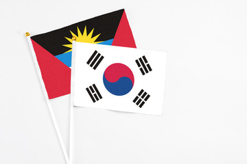 South Korea and Antigua and Barbuda stick flags on white background. High quality fabric, miniature national flag. Peaceful global concept.White floor for copy space.