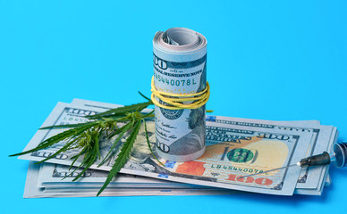 folded cash US dollars, green hemp leaf