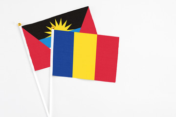 Romania and Antigua and Barbuda stick flags on white background. High quality fabric, miniature national flag. Peaceful global concept.White floor for copy space.